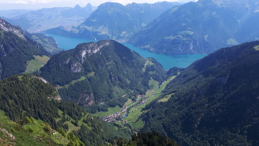 Von der Chulm auf 1970 Meter über Meer bietet sich ein imposanter Tiefblick auf das Dorf Isenthal und auf den links davon gelegenen Hausberg Scheidegg mit dem Mundartweg. Im Hintergrund sind Schwyz mit den beiden Mythen, Morschach/Fronalpstock und Axen/Rophaien zu erkennen. (Bild: Josef Gasser, 28. Juni 2018)