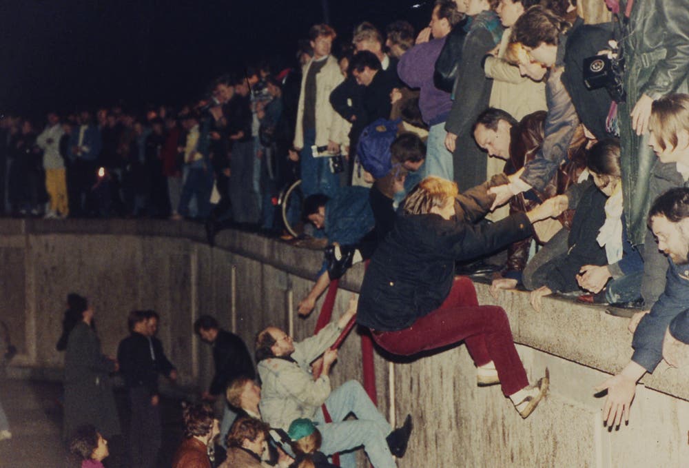 Ostberliner helfen Westberlinern in der Nacht über die Mauer. (Bild: Jockel Finck / Keystone, 9. November 1989)