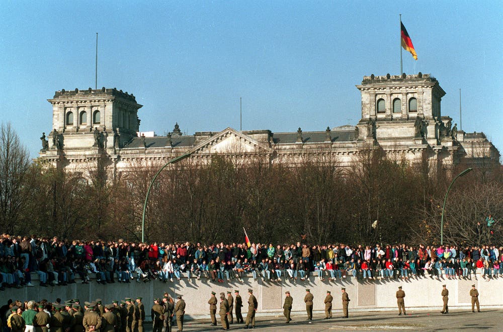 Deutsche aus dem Westen und Osten stehen auf der Mauer vor dem Reichstagsgebäude. (Bild: Keystone / AP, 9. November 1989)