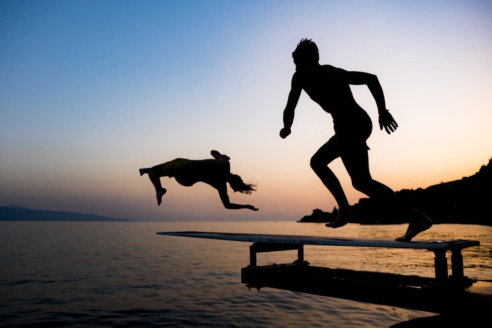 Zwei Personen springen bei Saint-Saphorin in den Genfersee. (Bild: Jean-Christophe Bott / Keystone, 26. Juni 2019)