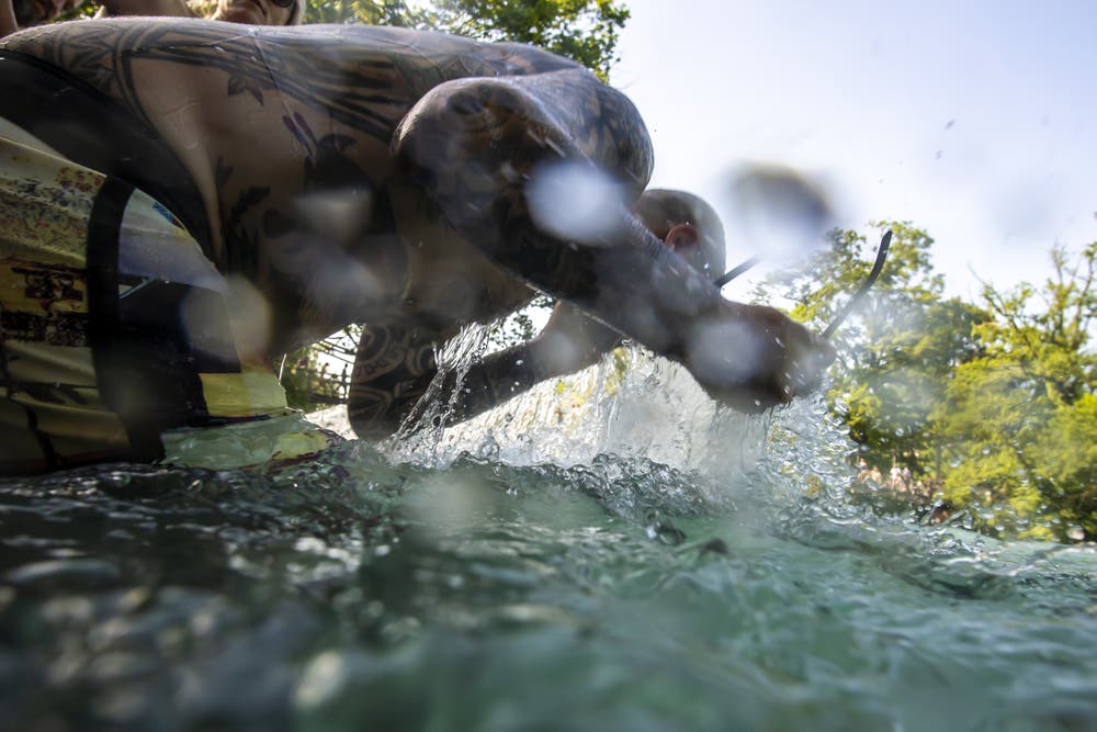 Ein Mann erfrischt sich in der Aare. (Bild: Anthony Anex / Keystone)