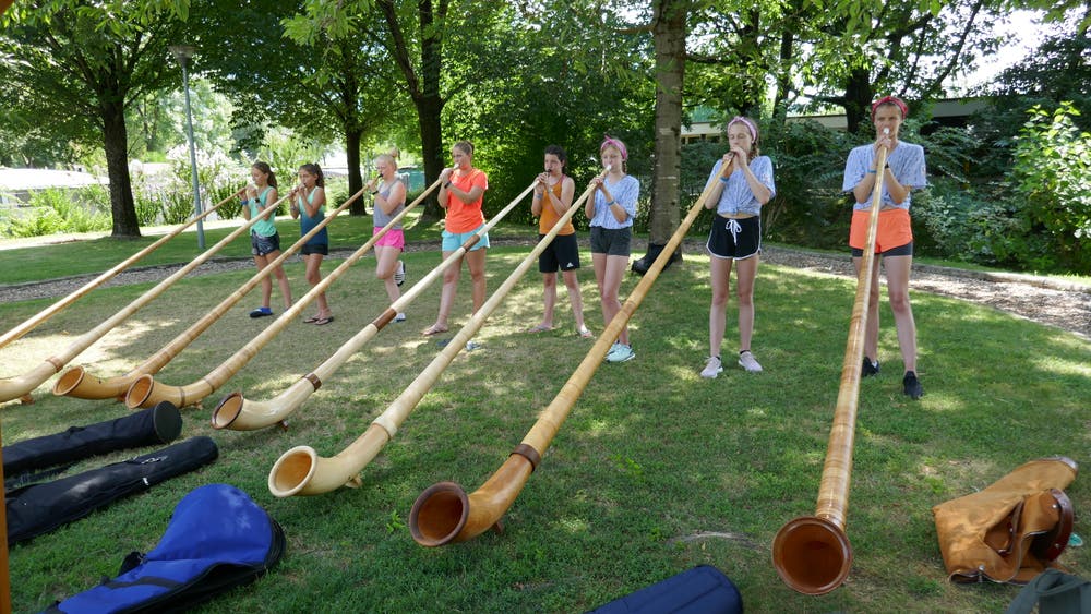 Diese Mädchen dürfen sich im Sportlager auch einmal im Alphornblasen versuchen. (Lagerbild: Kantonales Sportlager Zug, Tenero, 18. Juli 2019)