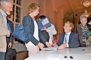 Historiker Josef Kunz signiert nach dem Festakt im Festsaal des Klosters Muri sein Jubiläumsbuch. (Bild: Christian Breitschmid)