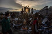 Einwohner auf einem Trümmerhaufen in der zerstörten indonesischen Stadt Palu auf Sulawesi. (Bild: Ulet Ifansasti/Getty (Palu, 10. Oktober 2018))