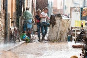 Noch während des Regens tragen Einwohner ihre Habseligkeiten auf der Strasse zusammen. (Bild: Francisco Ubilla/AP (Sant Llorenc, 10. Oktober 2018))