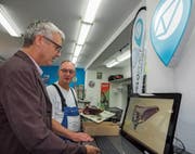 Digitales und Laden vor Ort vernetzt: Der St. Galler Fachhändler Bruno Pfiffner (hinten) mit einem Kunden am Veloplace-Terminal. (Bild: Peter Hummel)