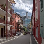 Das Hostel «Lion Lodge» (rosa Gebäude links), fotografiert im Juli 2018 von der Steinenstrasse aus. Die Baustangen zeigen ein relativ hohes Neubauprojekt an; dieses wurde bei der zweiten Auflage erheblich reduziert. (Bild Manuela Jans (13. Juli 2018)