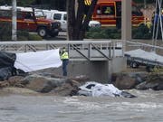 Rettungskräfte bergen die Leichen von zwei Menschen aus einem Auto, das von einem über die Ufer getretenen Fluss mit ins Meer gerissen wurde. (Bild: KEYSTONE/EPA/SEBASTIEN NOGIER)