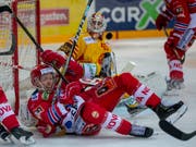 Der Puck in der Luft und die Spieler um Langnaus Torhüter Damiano Ciaccio am Boden (Bild: KEYSTONE/PATRICK B. KRAEMER)