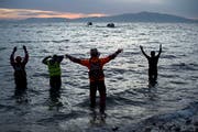 Freiwillige Helfer und Rettungskräfte lotsen ein Flüchtlingsboot vor Lesbos ans Ufer. (Bild: Alexander Koerner/Getty (12. März 2016))