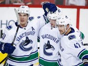 Sven Bärtschi (rechts) feiert den siegbringenden Treffer zum 3:2 mit seinen Teamkollegen (Bild: KEYSTONE/AP The Canadian Press/JEFF MCINTOSH)