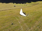 Nach der harten Landung liegt der motorisierte Deltaflügel auf einer Wiese im jurassischen Le Prédame: Der Pilot und dessen Tochter wurden verletzt. (Bild: Kapo Jura)