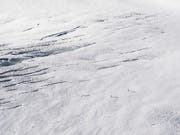 Zwei Wanderer auf dem Jungfraufirn in rund 3500 Meter Höhe: Trotz viel Neuschnee sind die Gletscher in der Schweiz unter der Sommersonne dahin geschmolzen. (Bild: KEYSTONE/ANTHONY ANEX)