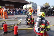 Die Feuerwehrleute demonstrieren die beschwerliche und gefährliche Abdichtung von Lecks am gekippten Tankwagen. (Bild: Eddy Schambron)