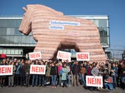 Personen demonstrieren in Bern mit einem Trojanischen Pferd gegen die Selbstbestimmungsinitiative der SVP. (Bild: KEYSTONE/PETER SCHNEIDER)