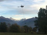 Ein Löschhelikopter holt im Umland von Savièse VS Wasser, um einen Waldbrand in der Nähe zu bekämpfen. (Bild: Kantonspolizei Wallis)