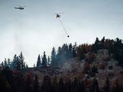 Am Samstag konnten wegen des schlechten Wetters keine Helikopter gegen den Waldbrand eingesetzt werden, dafür half der Regen den Löschequipen. (Bild: KEYSTONE/JEAN-CHRISTOPHE BOTT)