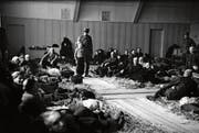 Robert Narev (Bildmitte) mit einem Soldaten nach der Ankunft im Hadwig-Schulhaus im Februar 1945. Die Turnhalle wurde damals als Strohlager für jüdische Flüchtlinge hergerichtet. (Bild: Ringier-Archiv)
