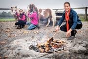 Denise Neuweiler beim Feuermachen an der Grillstelle oberhalb von Zuben mit den zwei Töchtern Flurina (links) und Leana.Bild: Reto Martin