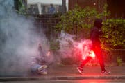 Ein Krawalltourist läuft mit der Pyro nach seiner Attacke gegen eine Frau weg. (Bild: Ennio Leanza/Keystone (Zürich, 1. Mai 2015))