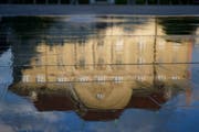Die Nationalbank spiegelt sich im Wasser des Brunnens auf dem Bundesplatz. (KEYSTONE/Peter Klaunzer)