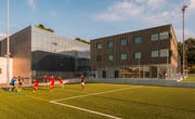 Das neue Sport- und Vereinsgebäude kommt künftig zwischen den beiden Rasenplätzen des Sportclubs Weggis zu stehen. (Visualisierung: PD)