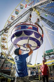 Das Herzstück des Herbstjahrmarktes: Arbeiter montieren die Kabinen des Riesenrads. (Bild: Ralph Ribi)