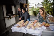 Backen am Samstagvormittag: Joe Müggler steht am Ofen, während die Co-Präsidentinnen Doris Roos Kliem und Alice Schlaginhaufen die verschiedenen Backwaren vorbereiten. (Bild: Reto Martin)