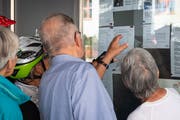 Interessierte Bürgen studieren den Ausgang der Wahlen am Aushang beim Rathaus Menzingen. (Bild: Christian H. Hildebrand, 7. Oktober 2018))