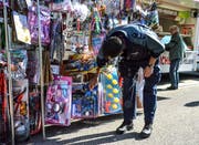 Auf der Suche nach einer neuen Dienstwaffe? Oder nach Handschellen? Ein Polizist begutachtet am Fischinger Jahrmarkt das Angebot eines Spielzeugstandes. (Bilder: Christoph Heer)