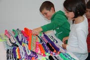 Die Kinder freuen sich über die Stirnbänder, welche sie im Dunkeln sichtbar machen werden. (Bild: Flurina Lüchinger)