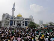 Anhänger des geschassten Ministerpräsidenten Ranil Wickremesinghe demonstrieren ihre Unterstützung vor dem offiziellen Sitz des Regierungssitz in Colombo. (Bild: KEYSTONE/AP/ERANGA JAYAWARDENA)