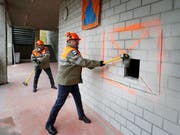 Die Regierungsräte Beat Villiger (links) und Urs Hürlimann hauen für den «Spatenschlag» in der Schönau tüchtig drauf.(Bild: Stefan Kaiser (Cham, 31. Oktober 2018))