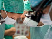 Der Mundschutz schützt sowohl die Patienten als auch das medizinische Personal, schafft aber auch Distanz. Eine transparente Maske soll dies künftig ändern. (Bild: KEYSTONE/GAETAN BALLY)