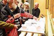 Die Wäldler diskutieren das Modell des Vorprojektes für das neue Dorfzentrum mit Gemeindekanzlei und angebautem Spar. (Bild: MC)