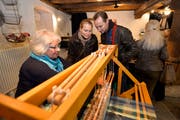 Der Handwebstuhl weckt das Interesse der Marktbesucher.
