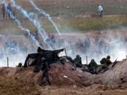 Israelische Soldaten und palästinensische Demonstranten treffen an der Grenze zum Gazastreifen aufeinander. (Bild: KEYSTONE/EPA/JIM HOLLANDER)