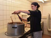 Sabina Seeberger, Konditor-Confiseurin beim Königsbeck in Zihlschlacht, klopft überschüssige Couverture von der Gussform ab. (Bild: Yvonne Aldrovandi-Schläpfer)