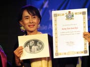Aung San Suu Kyi mit der Urkunde der Menschenrechtsorganisation Amnesty International, die ihr 2009 den Ehrentitel «Botschafterin des Gewissens» verliehen hatte. Nun hat Amnesty Suu Kyi den Titel entzogen. (Foto: KIM HAUGHTON/EPA) (Bild: KEYSTONE/EPA/KIM HAUGHTON)