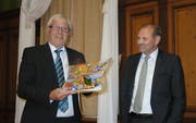 Projektleiter Werner Lenzin übergibt Gemeindepräsident Max Vögeli ein Fotobuch der Sommerkurse. (Bild: PD)