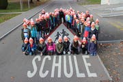Mit den leuchtenden Pylonis-Mützen ausgerüstete Zuger Schüler. (Bild: Zuger Polizei)
