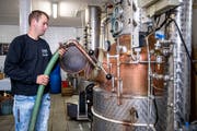 Jonas Stadelmann füllt in der Brennerei Stadelmann Maische in den Brennhafen. (Bild: Philipp Schmidli, Altbüron, 30. Oktober 2018)