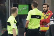 Schiedsrichter Paolo Silvio Mazzoleni (Mitte) schaut sich eine Szene im Match zwischen AC Milan und Juventus Turin am TV an. (Bild: Luca Bruno / AP (Mailand, 11. November 2018))