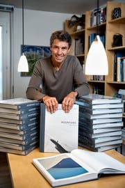Robert Bösch zu Hause in Oberägeri mit Bücherbergen seines neusten Werkes «Mountains». (Bild: Roger Grütter, 20. November 2018)