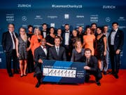 Die Laureus-Family mit dem Check in der Höhe von 1‘111'111 Franken (Bild: Keystone/David Biedert)