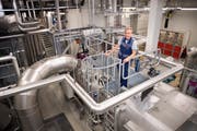 Der Leiter Haustechnik/Umwelt Josef Amrhein auf dem Dampfkessel des Biomasse-Heizkraftwerks. (Bild: PD)