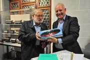 Matthias Halter, Präsident des Historischen Museums Uri (rechts), schenkte Remigi Joller an der Vernissage ein Modell eines Rega-Helikopters. (Bild: Urs Hanhart, 27. November 2018)
