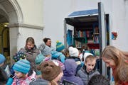 Die Primarschüler räumen die letzten Bücher in die selbstbemalten Regale ein. (Bild: GWF)