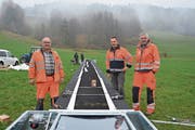 Theo Messmer, Betriebsleiter, Werner Messmer sowie Martin Giovanoli, Technischer Leiter, am letzten Freitagnachmittag bei der Installation des 30 Meter langen Förderbandes unweit des Gähwiler Skilifts (von links). (Bild: Beat Lanzendorfer)