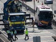 Nach der tödlichen Kollision zwischen einem Bus und einem Taxi in Hongkong räumen Arbeiter das Buswrack von der Autobahn. (Bild: KEYSTONE/EPA/JEROME FAVRE)